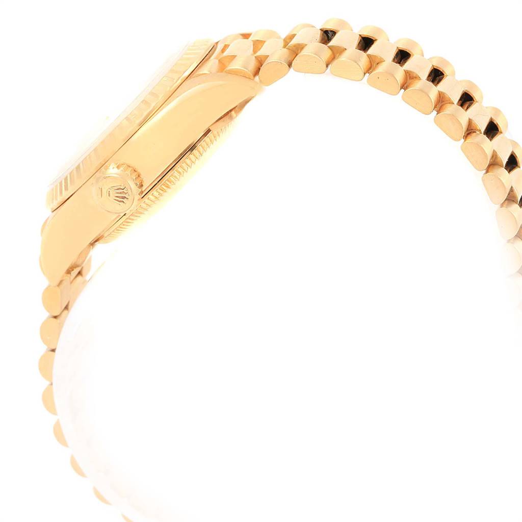The image shows a side view of a Rolex President 69178 Women's Yellow Gold Champagne Dial 69178 Women's Yellow Gold Champagne Dial watch, highlighting the crown and part of the gold bracelet.