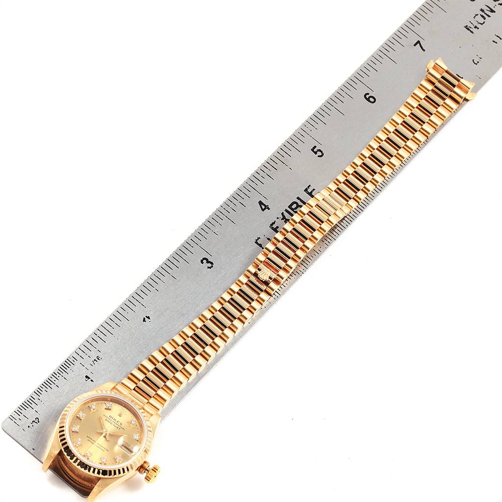 The Rolex President 69178 Women's Yellow Gold Champagne Dial 69178 Women's Yellow Gold Champagne Dial watch is shown at a high angle with its face and entire bracelet next to a ruler for scale.