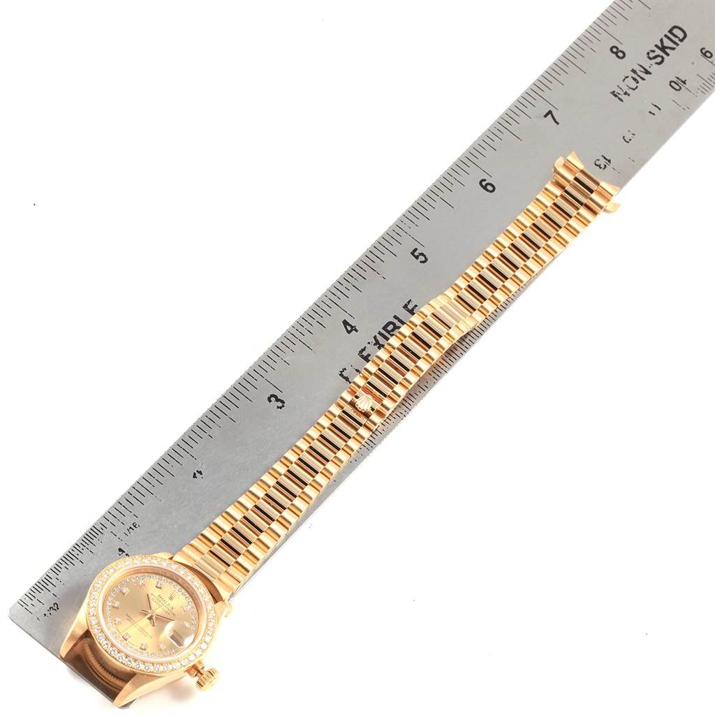 The image shows a Rolex President 69138 Women's Yellow Gold Champagne Dial 69138 Women's Yellow Gold Champagne Dial model watch laid flat, next to a ruler to measure the length of its bracelet.