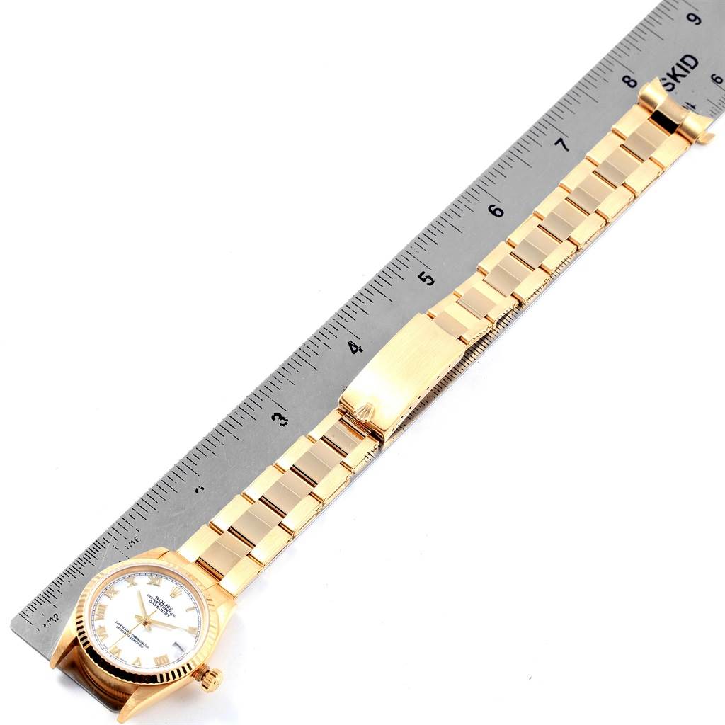 The image shows the Rolex President 78278 Women
s Yellow Gold White Dial 78278 Women
s Yellow Gold White Dial watch from an overhead angle, highlighting the bracelet and clasp alongside a ruler for scale.