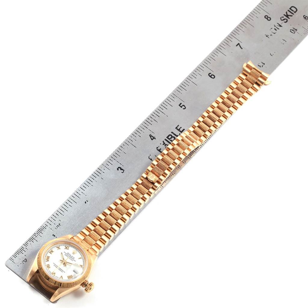 The image shows a Rolex President 69278 Women
s Yellow Gold White Dial 69278 Women
s Yellow Gold White Dial model watch laid flat, with a ruler beside it measuring its length.