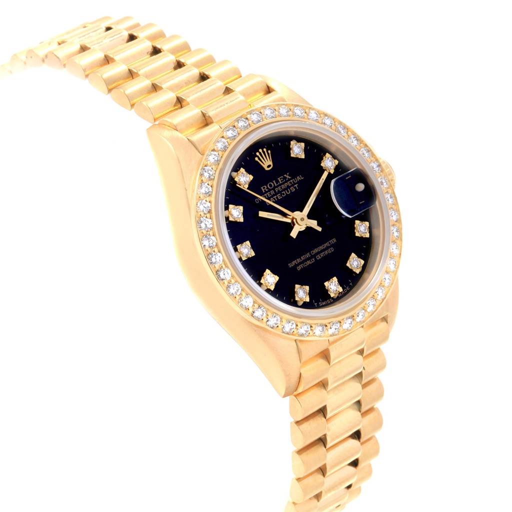 The image shows a Rolex President 69138 Women
s Yellow Gold Black Dial 69138 Women
s Yellow Gold Black Dial model watch at an angle, highlighting the diamond-studded bezel, black dial, and gold bracelet.