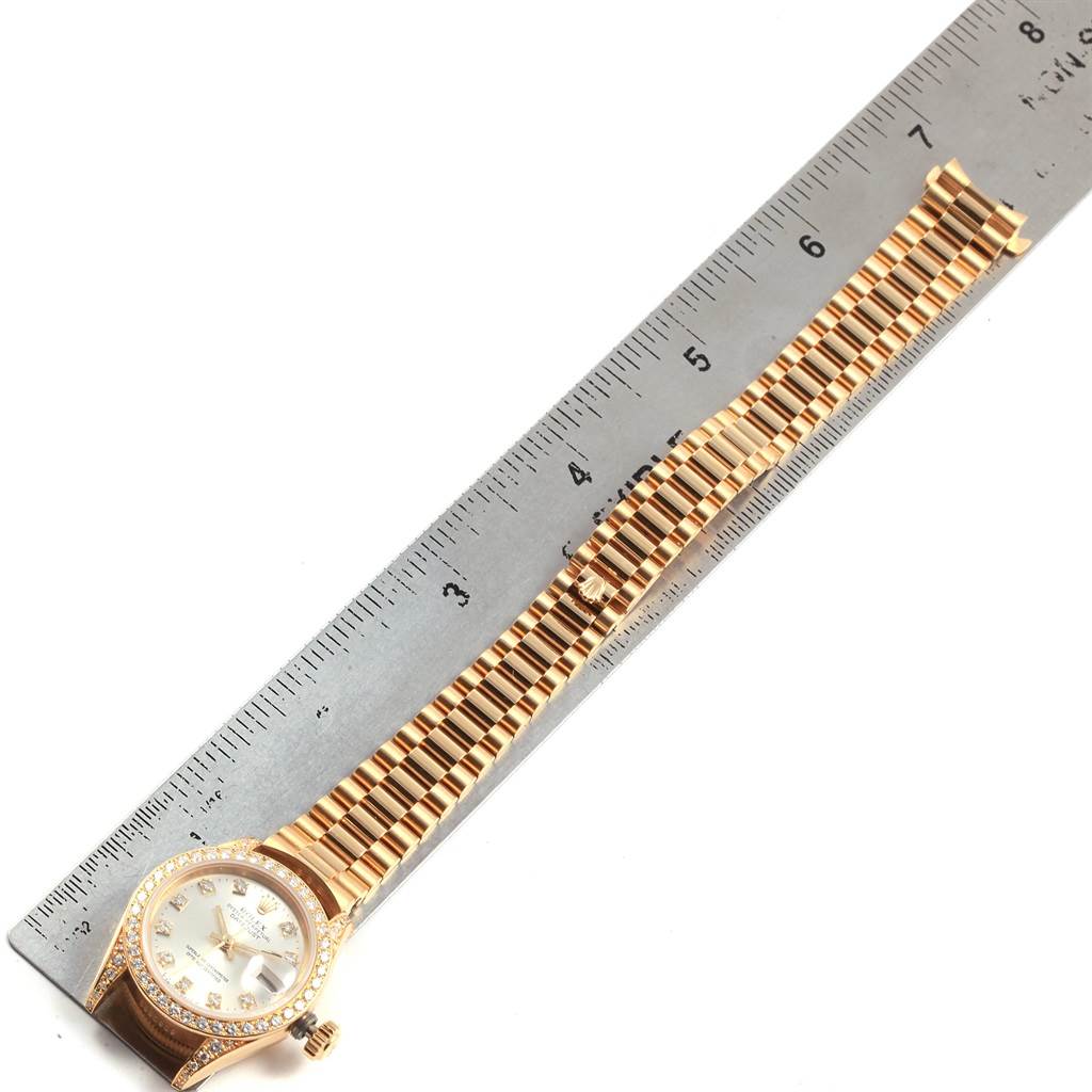 The image shows a Rolex President 69238 Women's Yellow Gold Silver Dial 69238 Women's Yellow Gold Silver Dial model watch laid flat next to a ruler, displaying the face, bezel, and entire band.