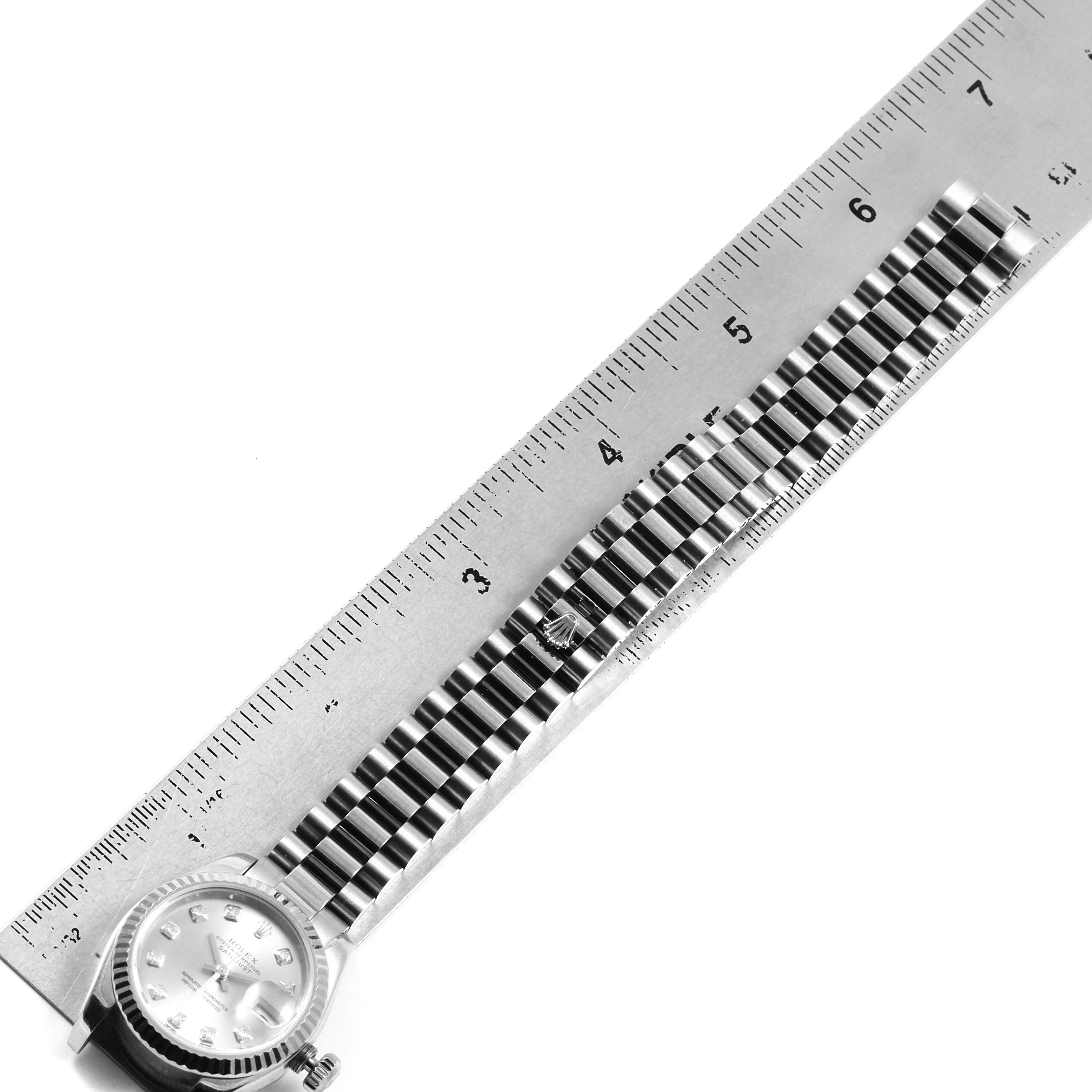 The image shows the Rolex President 179179 Women's White Gold Silver Dial 179179 Women's White Gold Silver Dial model watch placed alongside a ruler, displaying the face and band from a top-down angle.