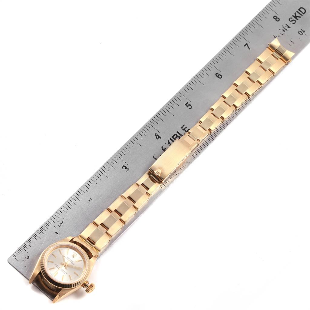 The image shows a Rolex President 67197 Women's Yellow Gold Silver Dial 67197 Women's Yellow Gold Silver Dial model watch laid flat next to a ruler, displaying its bracelet and face from above.