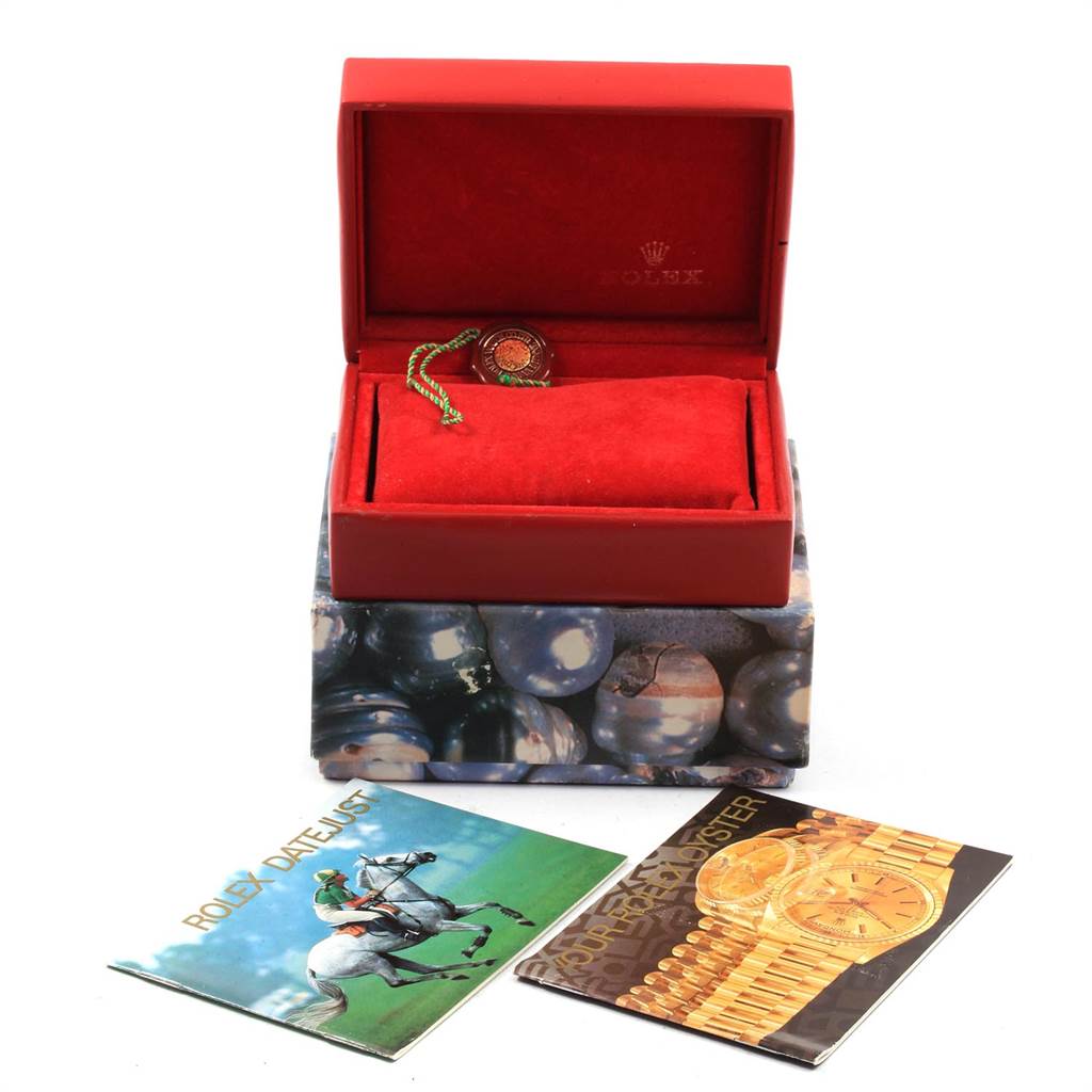 The image shows a red Rolex President 69158 Women
s Yellow Gold Mother of Pearl Dial 69158 Women
s Yellow Gold Mother of Pearl Dial model watch box, a tag, and two booklets placed at different angles.