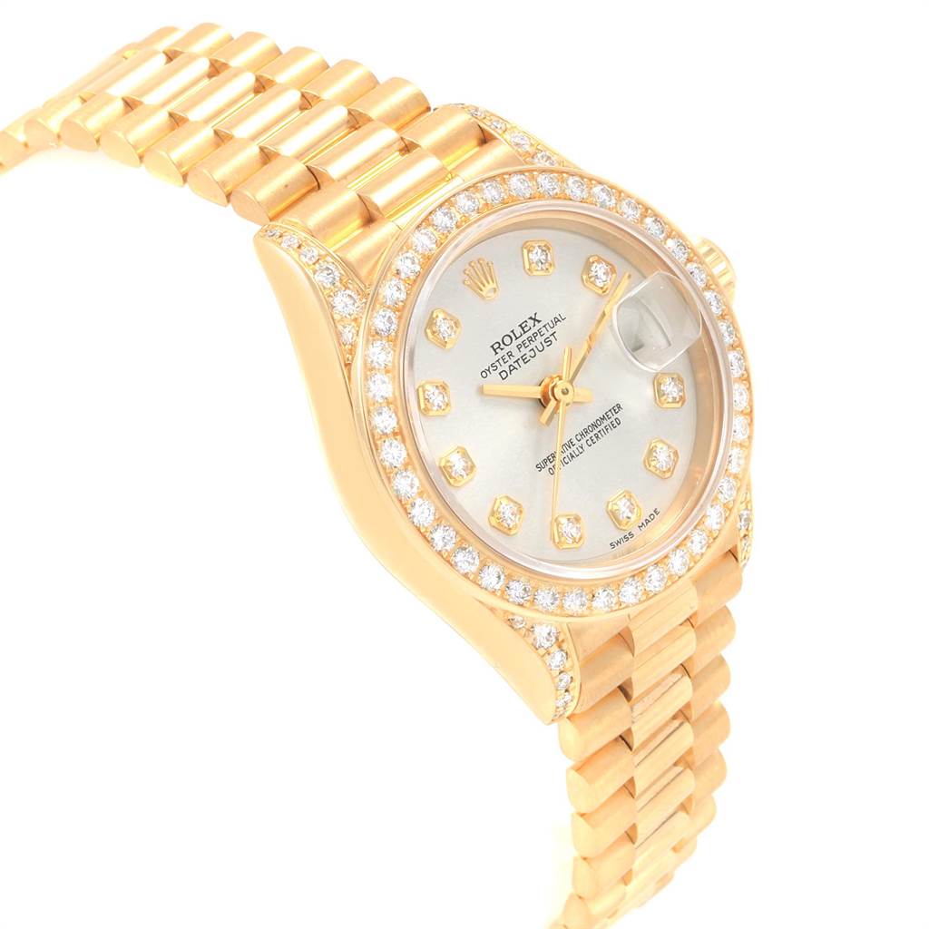 The President model by Rolex is shown at a slight angle, highlighting the diamond bezel, watch face, and part of the gold bracelet.