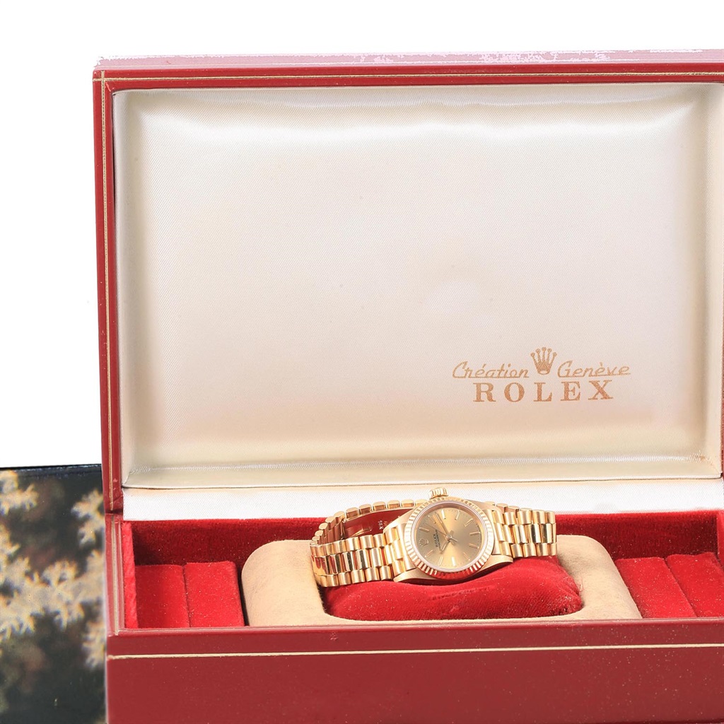 The image shows a Rolex President 67198 Women's Yellow Gold Champagne Dial 67198 Women's Yellow Gold Champagne Dial model watch laid flat in an open red and beige box.