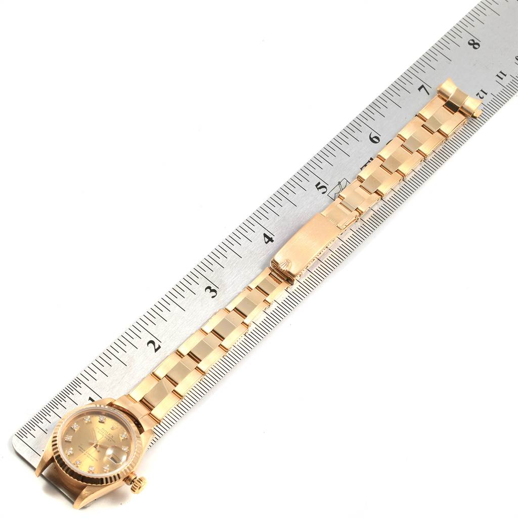 The image shows a Rolex President 69178 Women's Yellow Gold Champagne Dial 69178 Women's Yellow Gold Champagne Dial model watch with a focus on the band and the face, displayed alongside a ruler for scale.