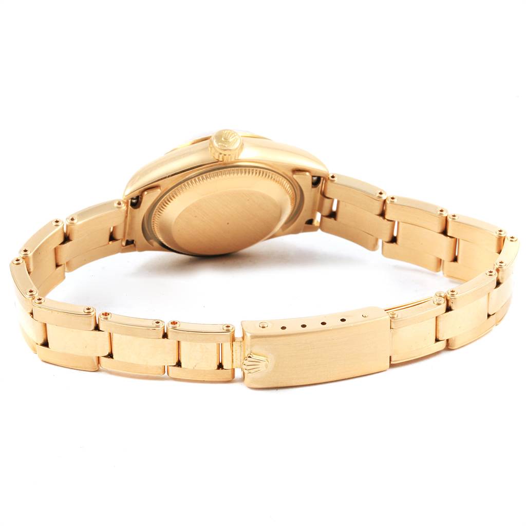 The image shows the back side of a Rolex President 69178 Women's Yellow Gold Champagne Dial 69178 Women's Yellow Gold Champagne Dial model watch, including its gold case back and bracelet with the clasp.