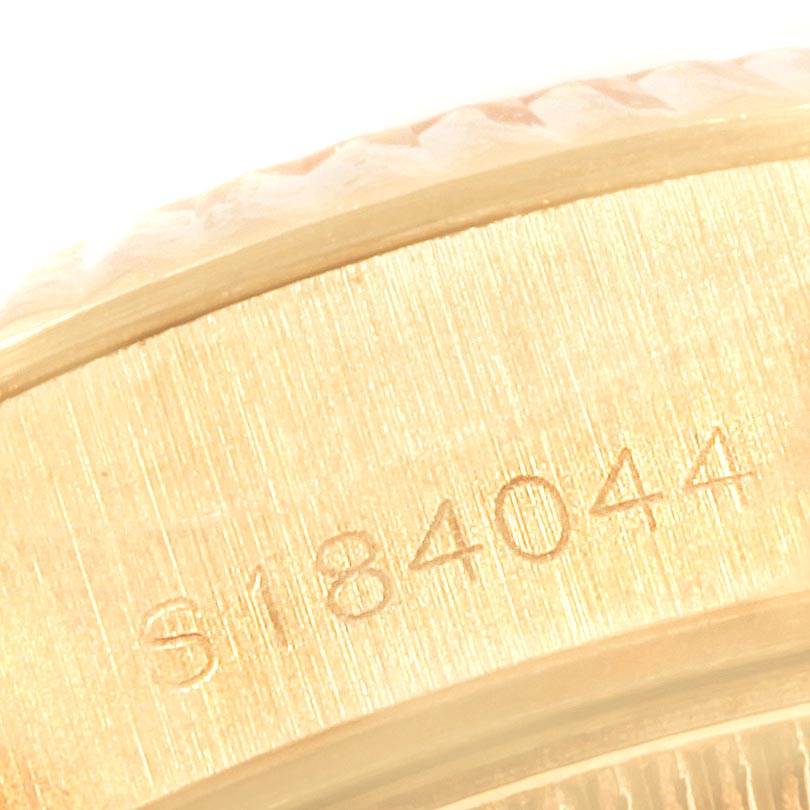 This close-up image shows a partial view of the serial number and the fluted bezel of a Rolex President 69178 Women's Yellow Gold Champagne Dial 69178 Women's Yellow Gold Champagne Dial model watch.