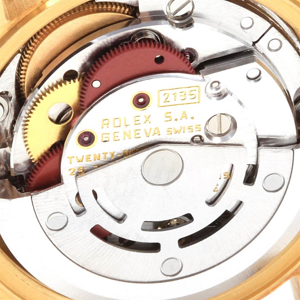 The image shows a close-up of the movement parts of a Rolex President 69178 Women
s Yellow Gold Champagne Dial 69178 Women
s Yellow Gold Champagne Dial model watch, highlighting the intricate gears and inscriptions.