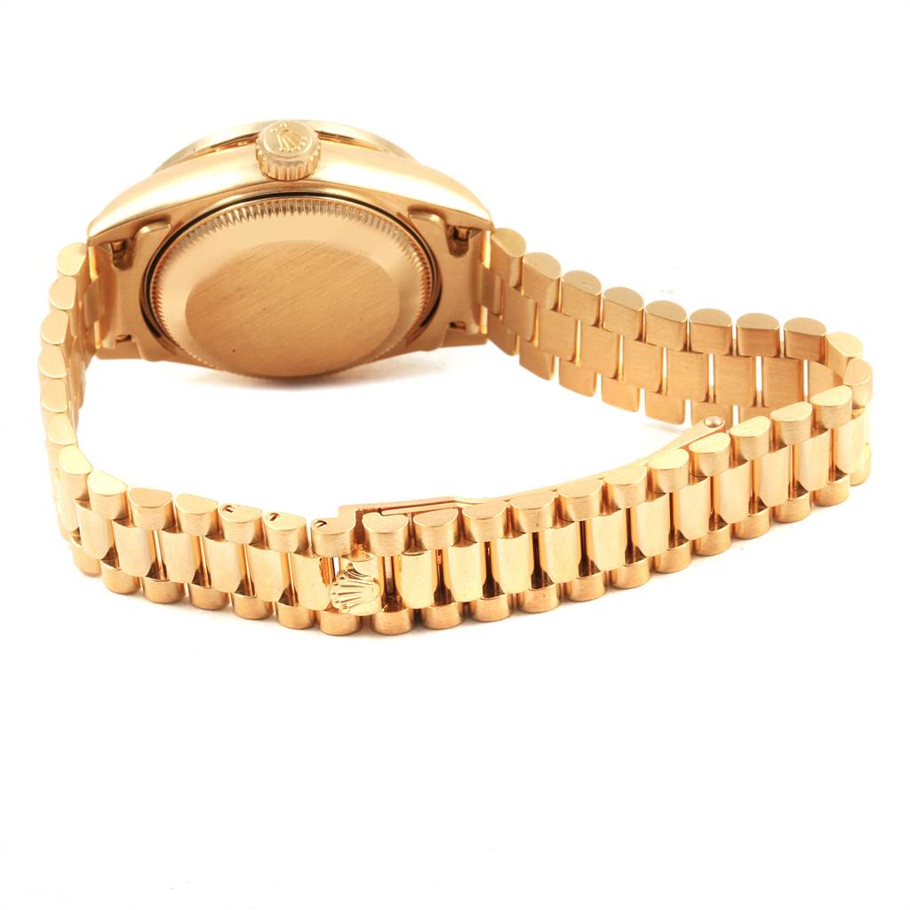 This image shows the back case, crown, and bracelet of a Rolex President 69138 Women
s Yellow Gold Mother of Pearl Dial 69138 Women
s Yellow Gold Mother of Pearl Dial model watch at a slight angle from the rear.