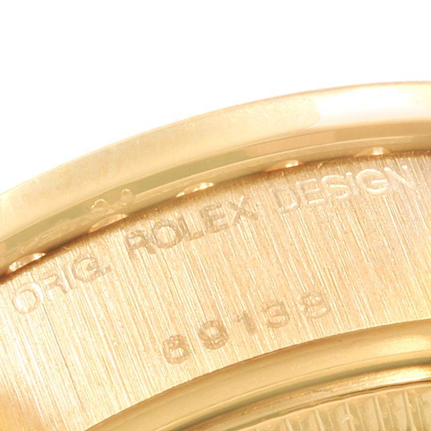 This image shows a close-up of the case back edge of a Rolex President 69138 Women
s Yellow Gold Mother of Pearl Dial 69138 Women
s Yellow Gold Mother of Pearl Dial model watch, displaying part of the engraving.