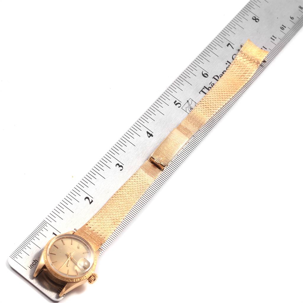 The image shows the face, band, and clasp of a Rolex President 6703 Women's Yellow Gold Champagne Dial 6703 Women's Yellow Gold Champagne Dial model watch laid beside a ruler.
