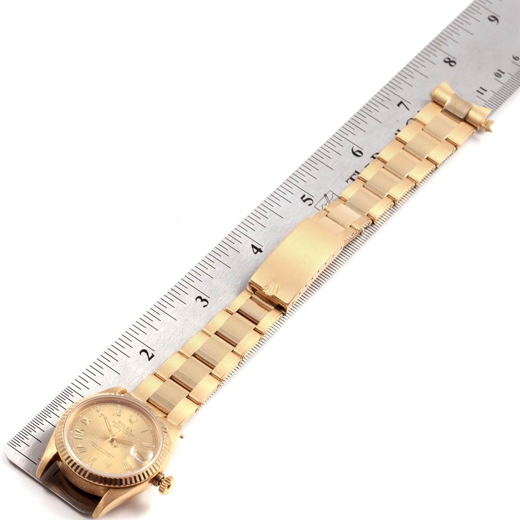 The Rolex President 68278 Women
s Yellow Gold Champagne Dial 68278 Women
s Yellow Gold Champagne Dial model watch is shown laid flat beside a ruler, displaying its bracelet, clasp, and dial.