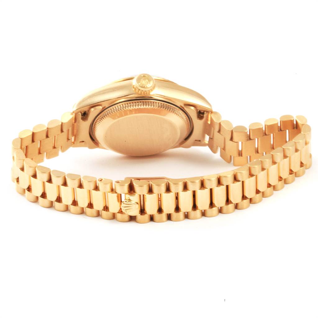 The image shows the back view of a Rolex President 69178 Women
s Yellow Gold White Dial 69178 Women
s Yellow Gold White Dial model watch, highlighting its case back and gold bracelet.