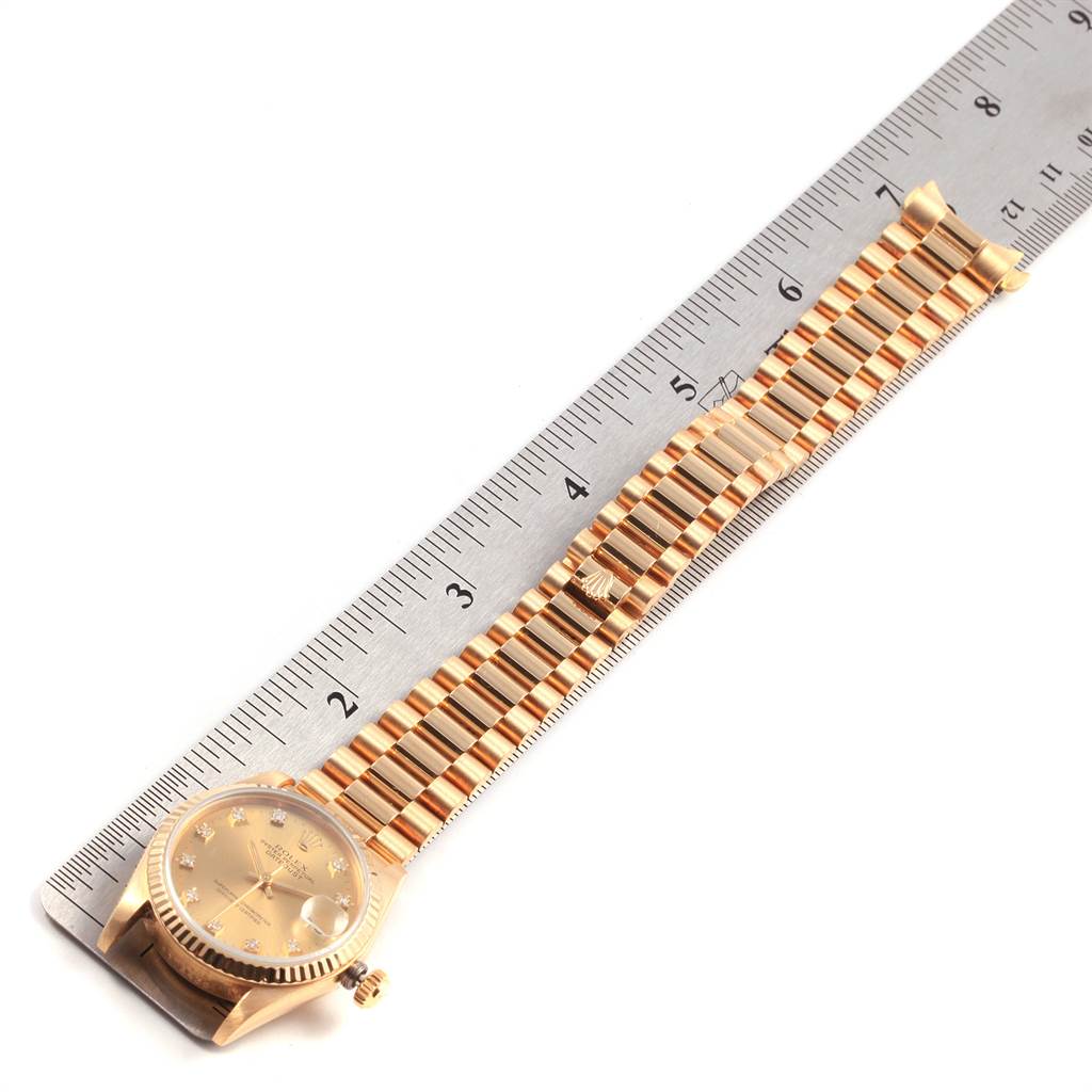 The Rolex President 68278 Women
s Yellow Gold Champagne Dial 68278 Women
s Yellow Gold Champagne Dial model watch is shown from a top-down angle, highlighting the face and bracelet against a ruler for scale.
