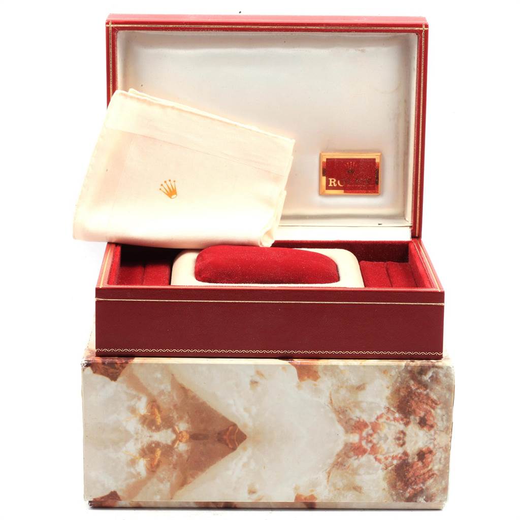 The image shows a Rolex President 6827 Women
s Yellow Gold Champagne Dial 6827 Women
s Yellow Gold Champagne Dial model watch box and cleaning cloth, positioned front-facing with an open lid.