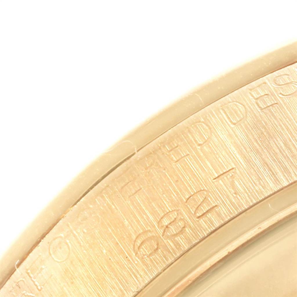 This image shows a close-up of the bezel of a Rolex President 6827 Women
s Yellow Gold Champagne Dial 6827 Women
s Yellow Gold Champagne Dial model watch, focusing on the engraved text on the edge.