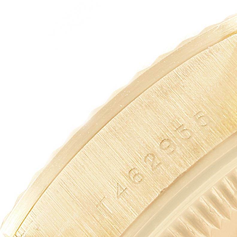 This close-up image shows part of the bezel and case back of a Rolex President 67198 Women
s Yellow Gold Black Dial 67198 Women
s Yellow Gold Black Dial model watch, emphasizing the engraved serial number.