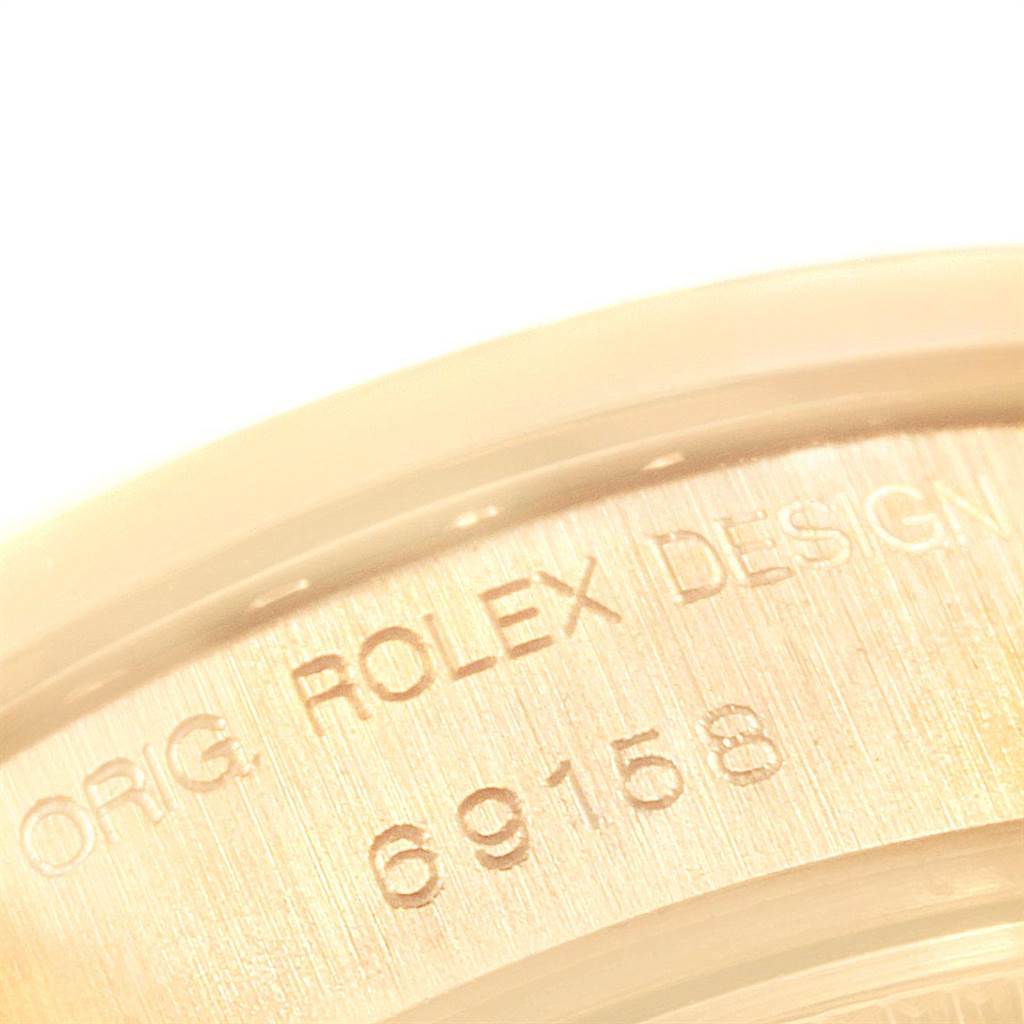 The image shows a close-up of the serial number and "ROLEX DESIGN" engraving on the bezel of a Rolex President 69158 Women
s Yellow Gold White Dial 69158 Women
s Yellow Gold White Dial watch.