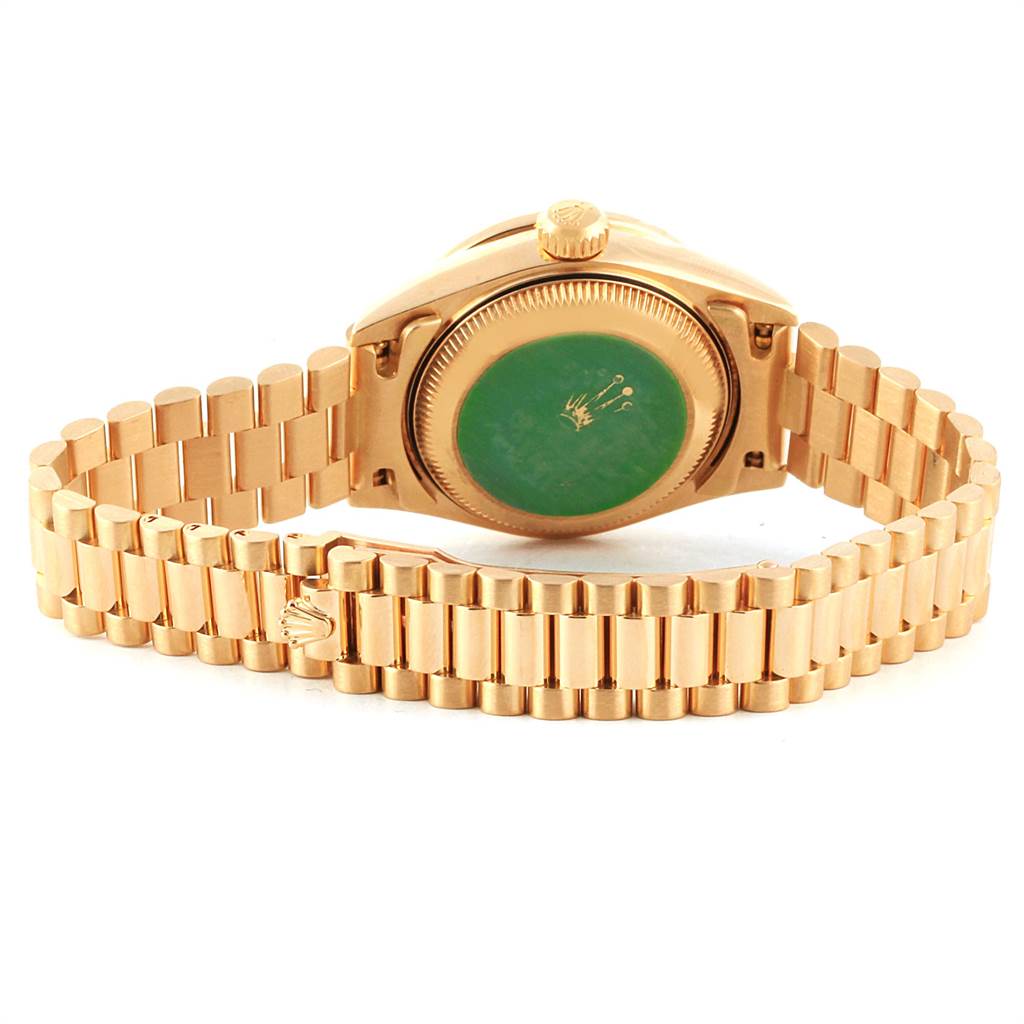 The image shows the case back and bracelet of a Rolex President 69158 Women
s Yellow Gold White Dial 69158 Women
s Yellow Gold White Dial model watch, featuring a gold tone and the signature green sticker.