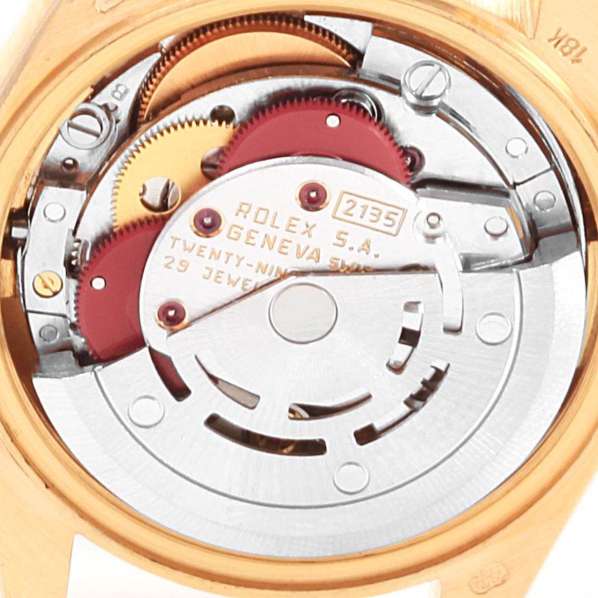 The image shows the intricate inner mechanism of a Rolex President 69278 Women
s Yellow Gold White Dial 69278 Women
s Yellow Gold White Dial model watch at an angle that reveals the movement and gears.