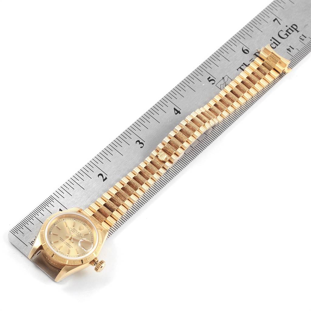 The image shows a Rolex President 69278 Women
s Yellow Gold Champagne Dial 69278 Women
s Yellow Gold Champagne Dial model watch with its face and full bracelet, aligned next to a ruler for size reference.