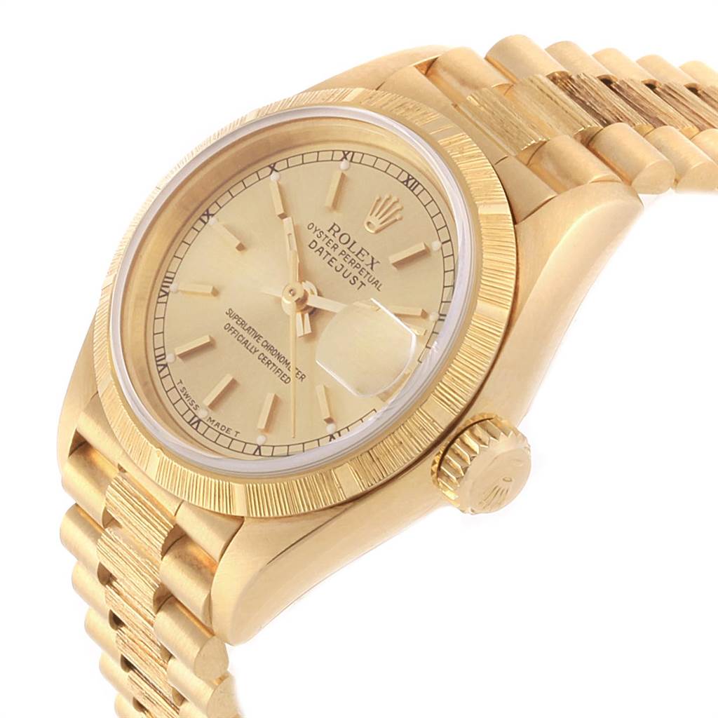The image shows a side view of a Rolex President 69278 Women
s Yellow Gold Champagne Dial 69278 Women
s Yellow Gold Champagne Dial watch, highlighting its gold dial, fluted bezel, and part of the bracelet.