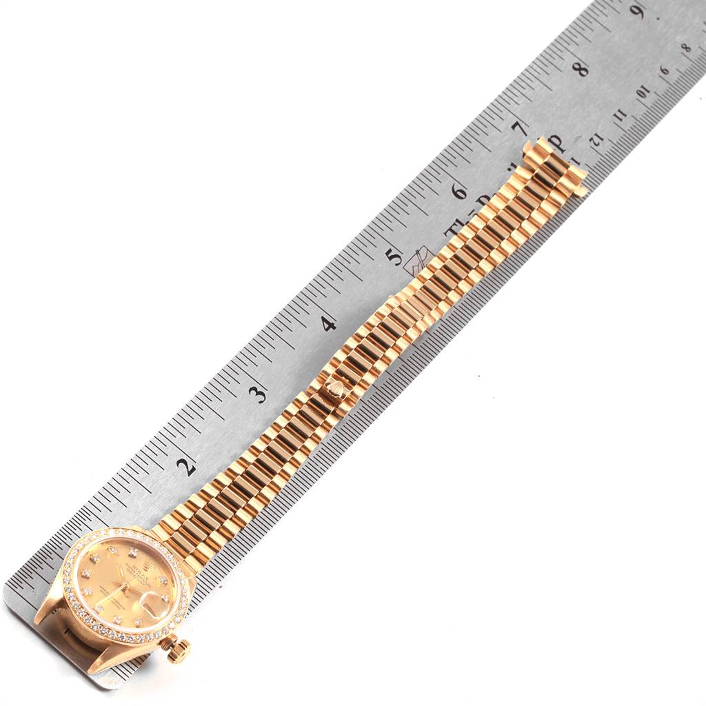 The image shows a Rolex President 69178 Women
s Yellow Gold Champagne Dial 69178 Women
s Yellow Gold Champagne Dial watch with a gold bracelet, placed next to a ruler for measurement.