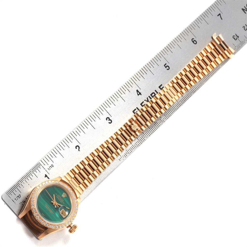 The Rolex President 69178 Women
s Yellow Gold Green Dial 69178 Women
s Yellow Gold Green Dial model watch is shown from the front with the face, bezel, and part of the bracelet visible next to a ruler.