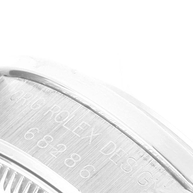 The image shows a close-up of the engraved bezel of a Rolex President 68286 Women's Platinum Silver Dial 68286 Women's Platinum Silver Dial model watch.