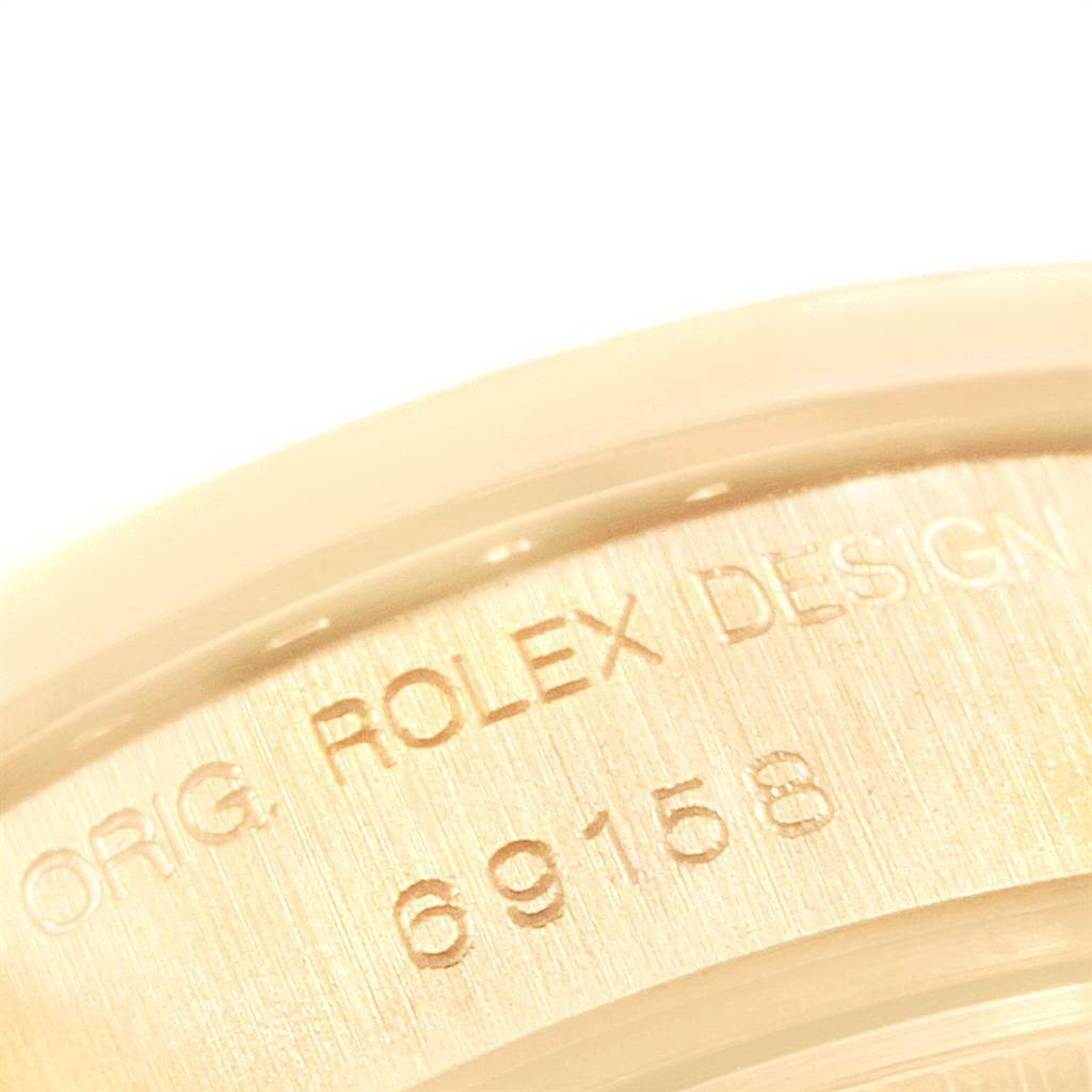 The image shows a close-up of the Rolex President 69158 Women
s Yellow Gold Champagne Dial 69158 Women
s Yellow Gold Champagne Dial watch model 69158 case with "ORIG. ROLEX DESIGN" engraved.