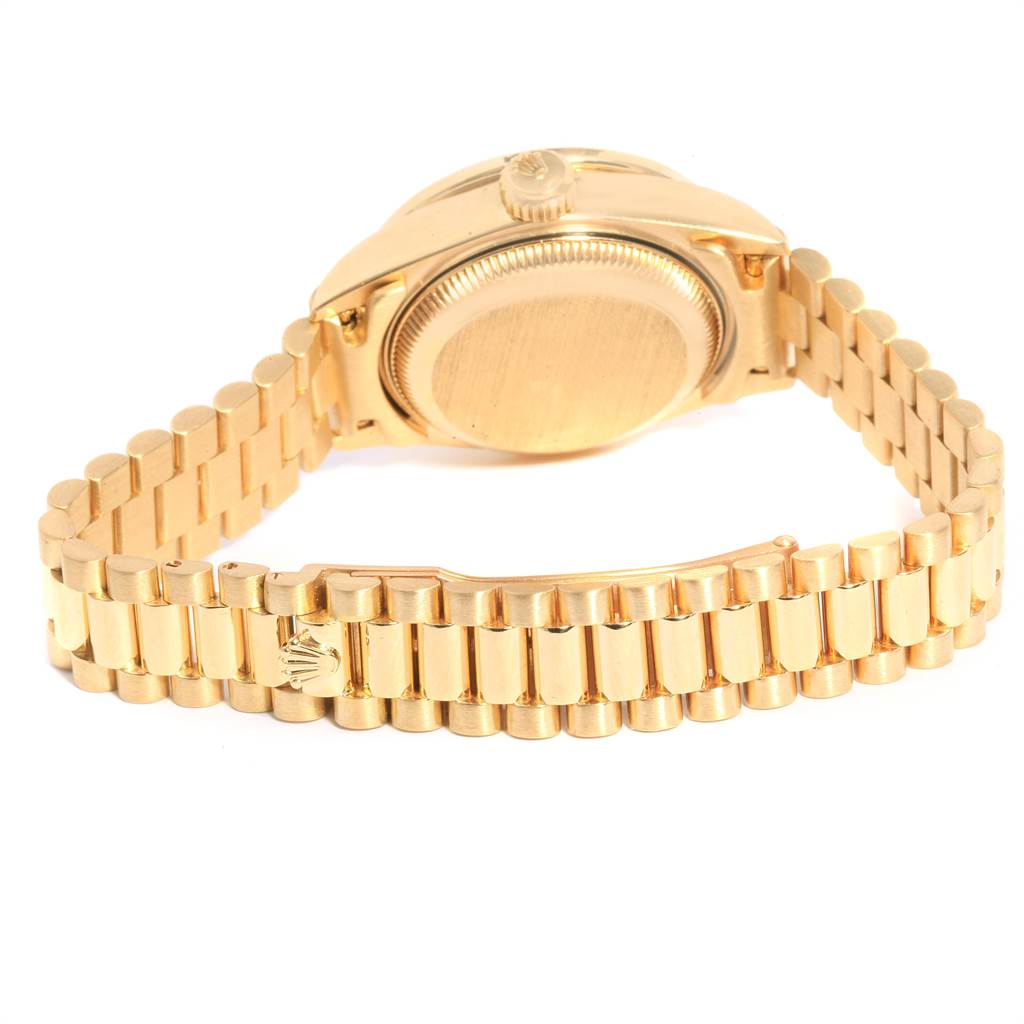 This image shows the back and bracelet of a gold Rolex President 69138 Women
s Yellow Gold Champagne Dial 69138 Women
s Yellow Gold Champagne Dial model watch at a slight angle from above.