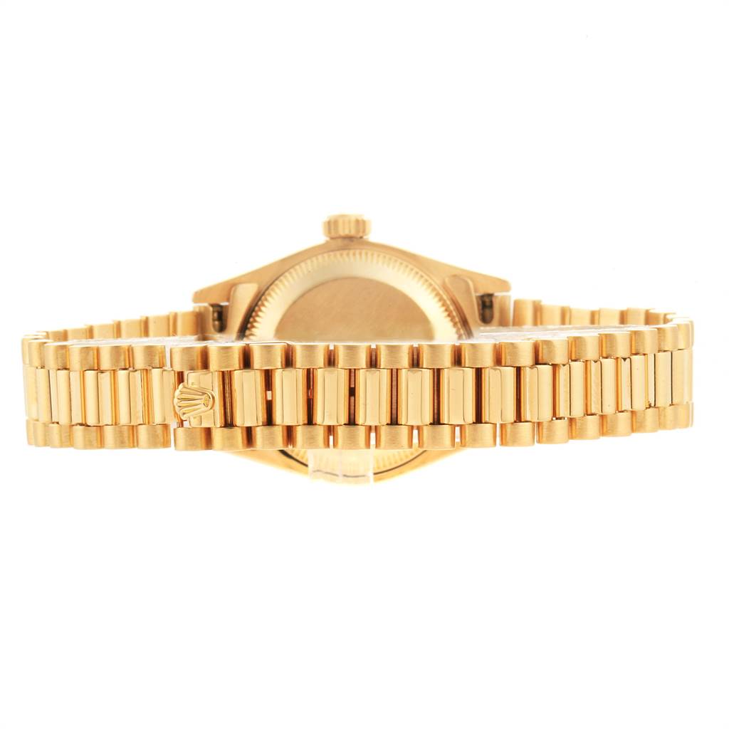 The image shows the back view of a gold Rolex President 69178 Women's Yellow Gold Black Dial 69178 Women's Yellow Gold Black Dial model watch, highlighting its band and clasp.