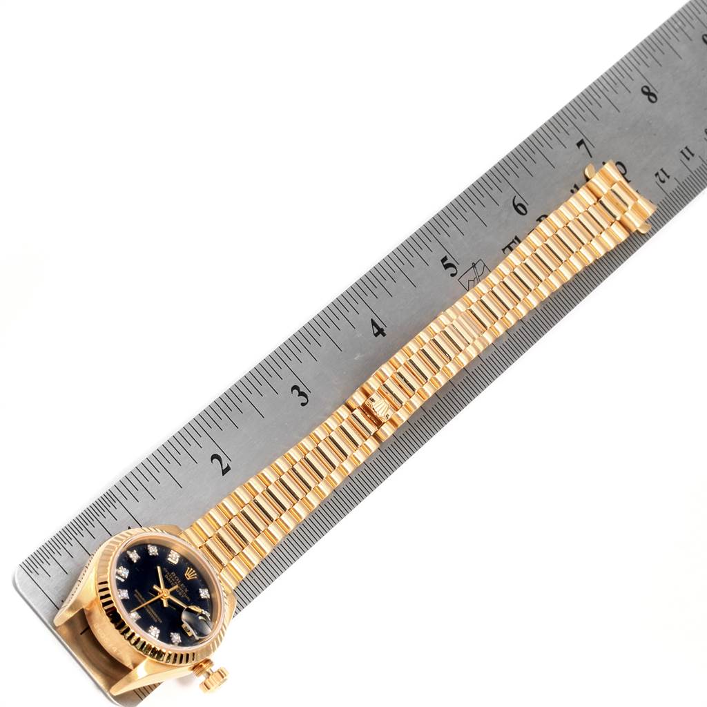 The image shows a Rolex President 69178 Women's Yellow Gold Black Dial 69178 Women's Yellow Gold Black Dial watch laid flat, with a ruler measuring its gold and black dial.