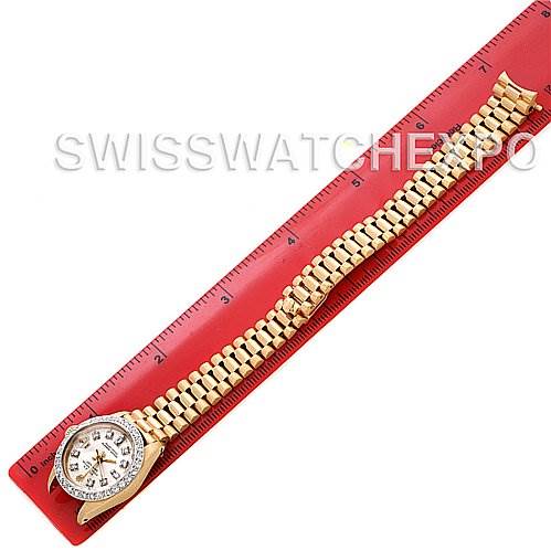 The Rolex President 6917 Women's Yellow Gold  6917 Women's Yellow Gold  watch is shown from a top-down angle, displaying the face and full bracelet placed alongside a ruler for scale.