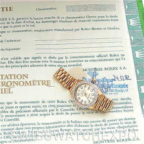 The image shows a Rolex President 6917 Women's Yellow Gold  6917 Women's Yellow Gold  model watch placed diagonally on top of its official warranty certificate.
