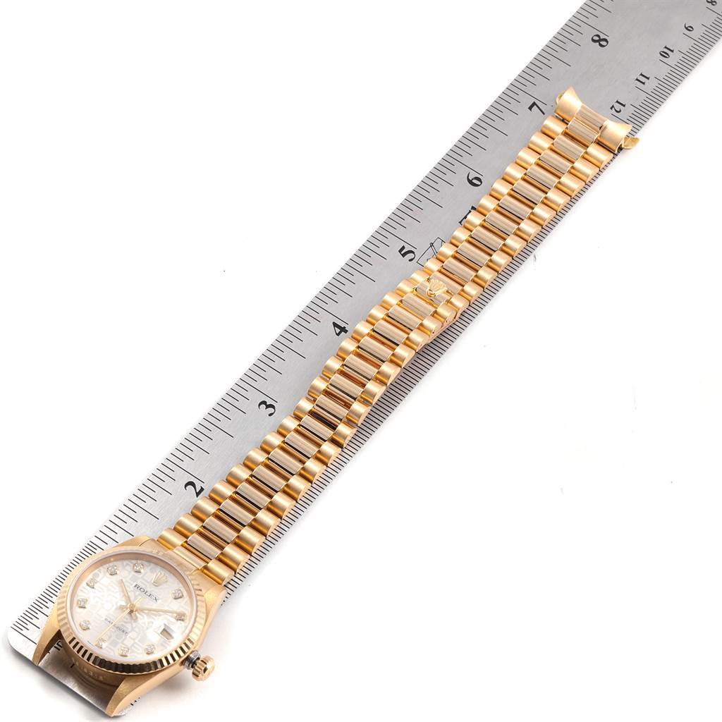 The image shows a top-down view of a Rolex President 68278 Women's Yellow Gold Silver Dial 68278 Women's Yellow Gold Silver Dial model watch, focusing on the dial and gold bracelet next to a ruler for measuring.