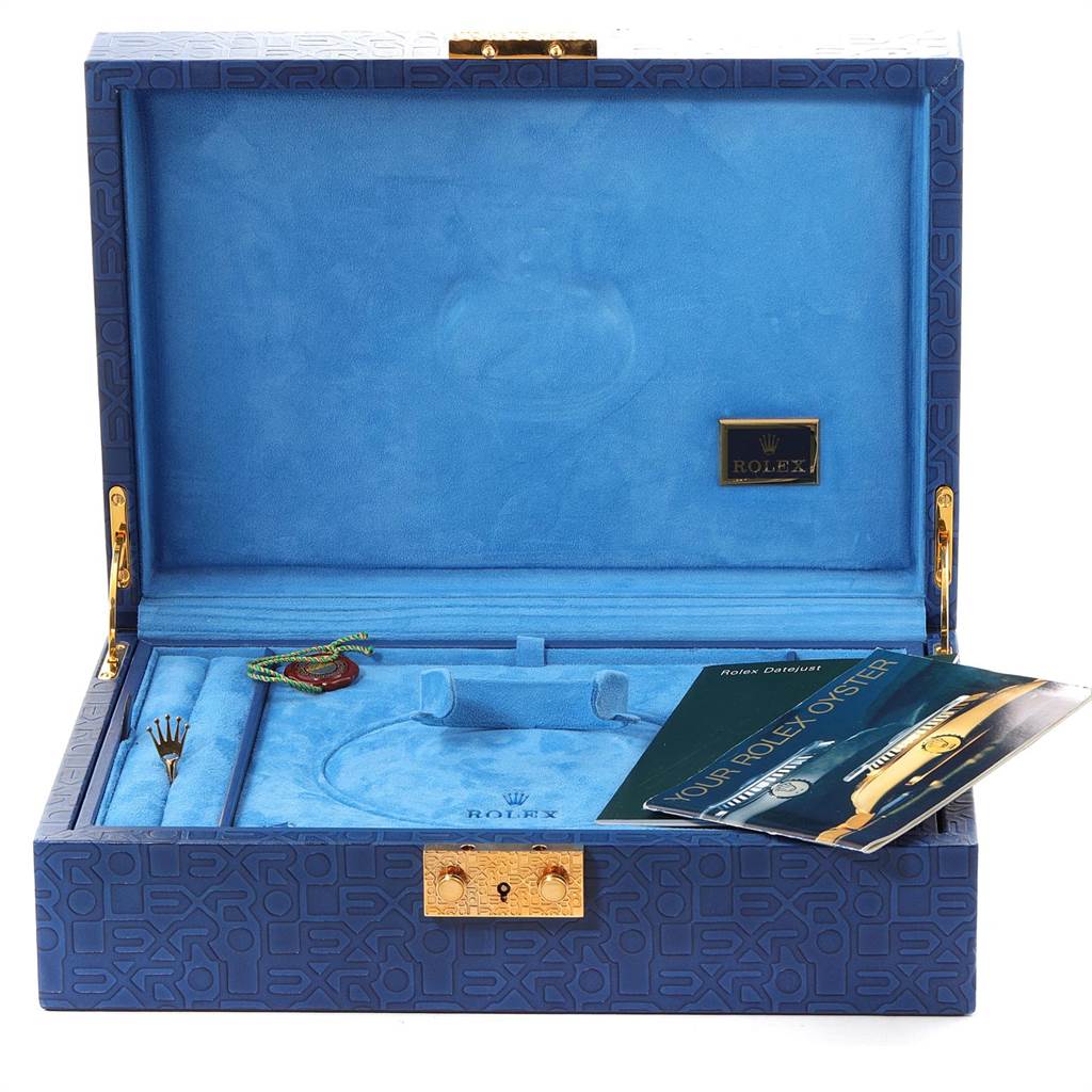 The image shows an open, blue Rolex box for the President model, containing accessories and a booklet.