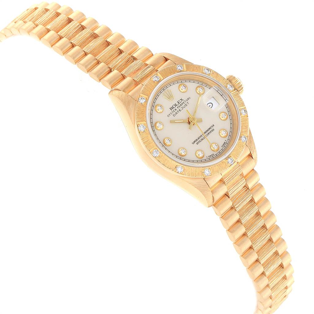 The image shows an angled view of a Rolex President 69288 Women's Yellow Gold Beige Dial 69288 Women's Yellow Gold Beige Dial watch, highlighting its bracelet, case, and dial with diamond hour markers.