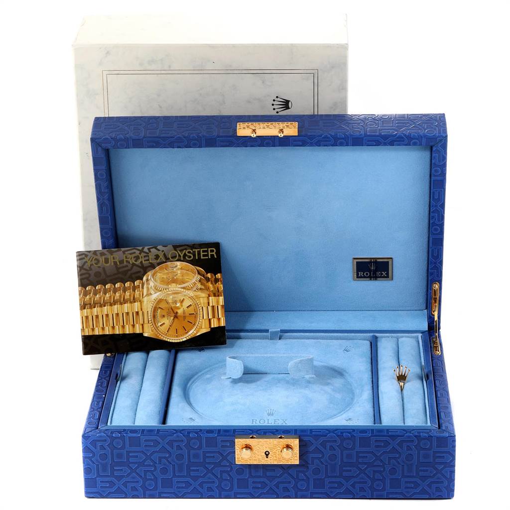 The image shows an open Rolex presentation box for the President model, displaying compartments, a brochure, and a tool.