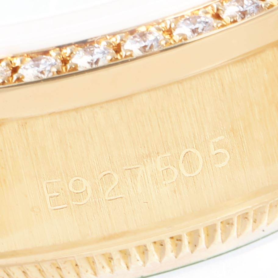 Close-up of the Rolex President 69138 Women's Yellow Gold Green Dial 69138 Women's Yellow Gold Green Dial model's gold case edge, featuring diamond detailing and serial number engraving.