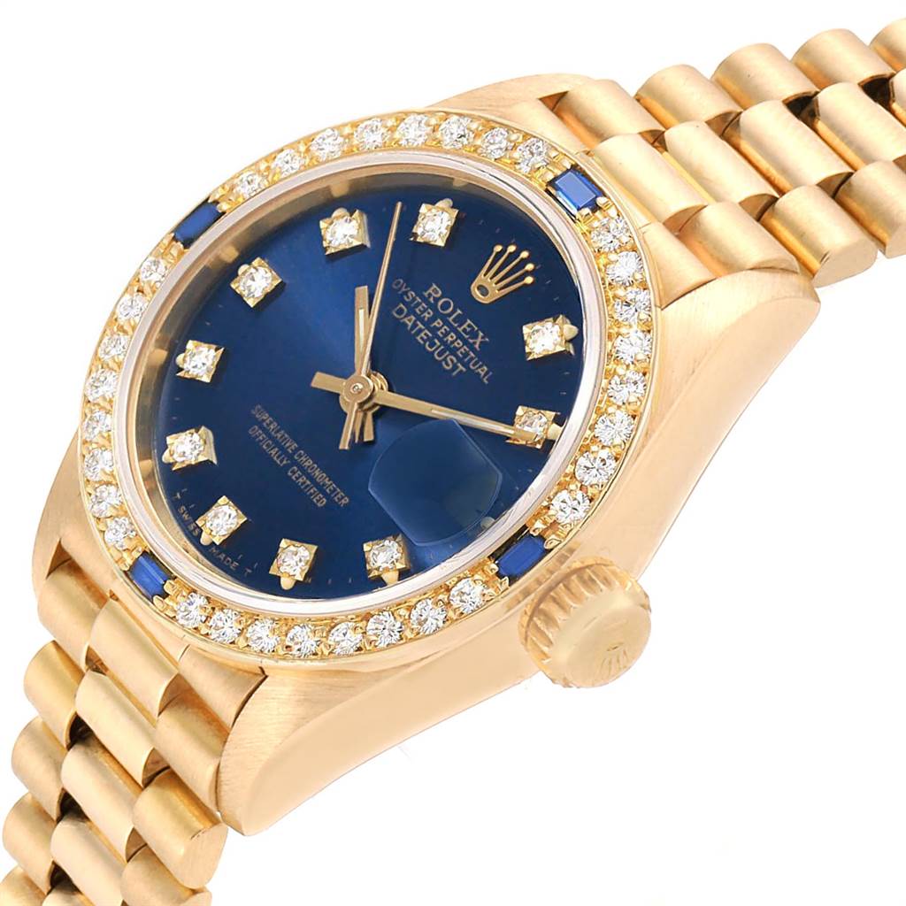 The image shows a Rolex President 69088 Women's Yellow Gold Blue Dial 69088 Women's Yellow Gold Blue Dial model watch at an angle highlighting the blue dial, diamond bezel, and gold bracelet.