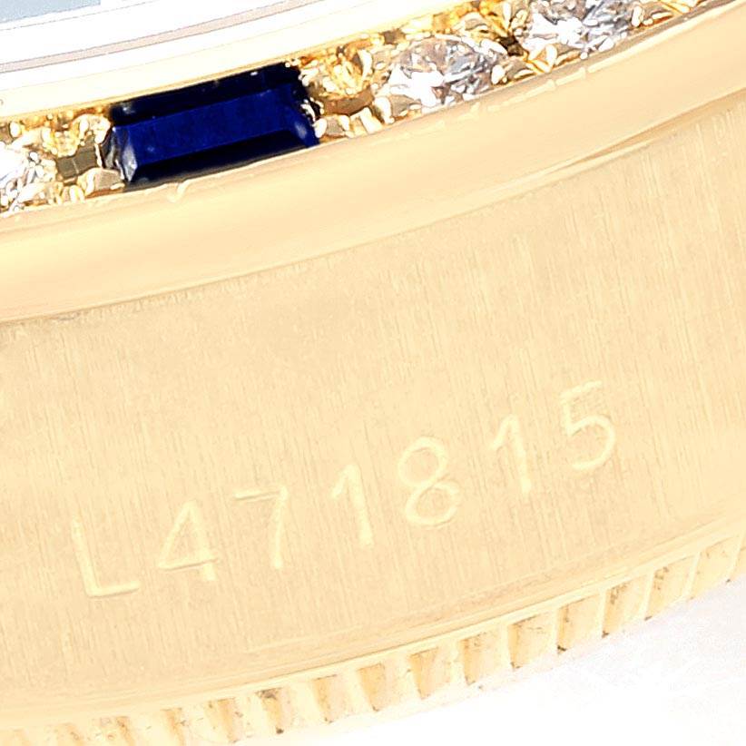 The image shows a close-up of the engraved serial number and diamond-encrusted bezel on a Rolex President 69088 Women's Yellow Gold Blue Dial 69088 Women's Yellow Gold Blue Dial model watch.