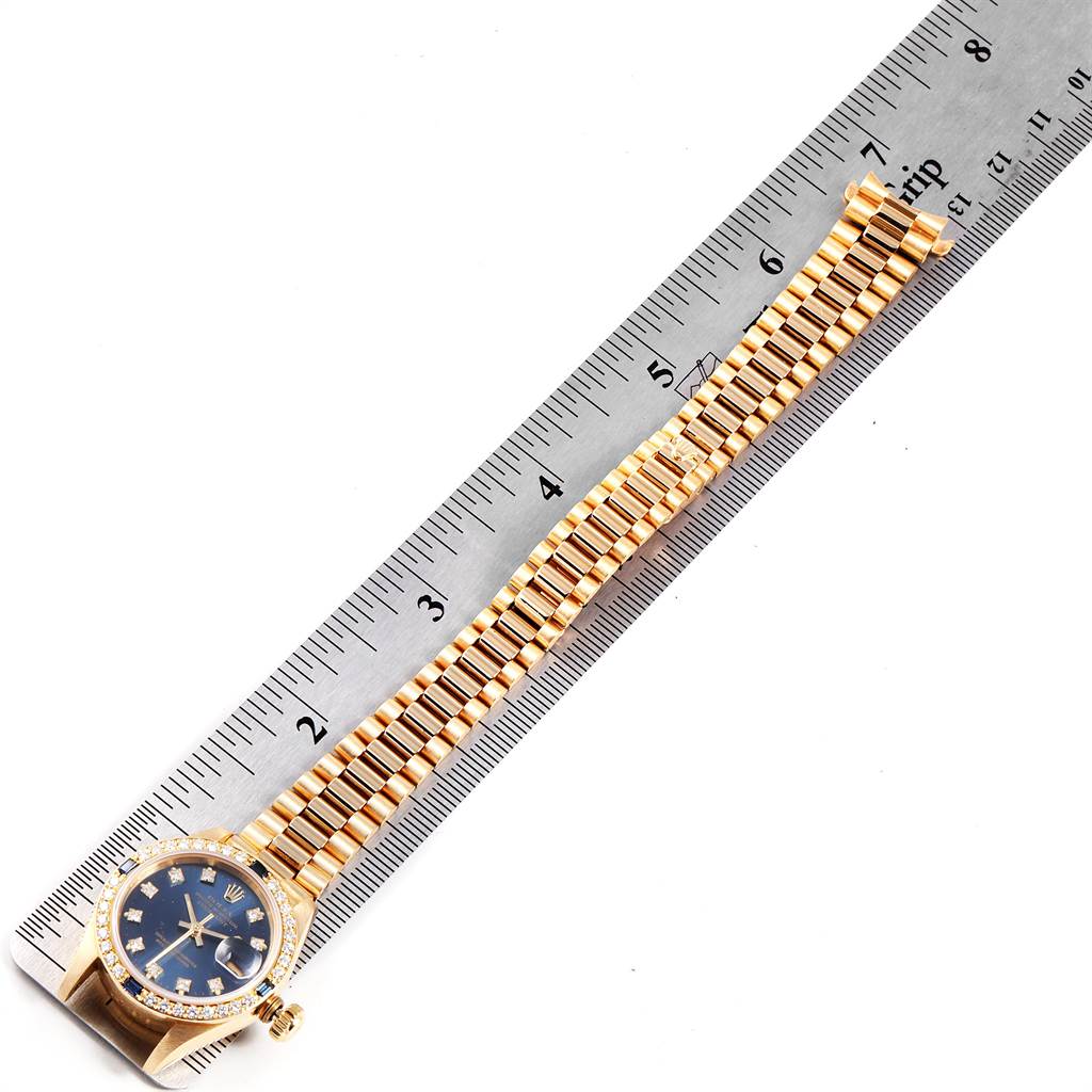 The image shows the Rolex President 69088 Women's Yellow Gold Blue Dial 69088 Women's Yellow Gold Blue Dial watch flat with the face and the full length of the band against a ruler for measurement.