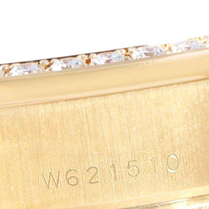 The image shows a close-up of the side of a Rolex President 69138 Women
s Yellow Gold White Dial 69138 Women
s Yellow Gold White Dial model watch, featuring its serial number and diamond accents.