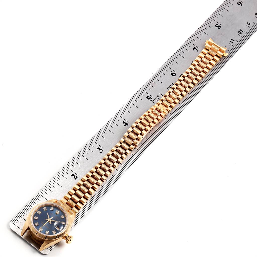 The Rolex President 69278 Women's Yellow Gold Blue Dial 69278 Women's Yellow Gold Blue Dial model watch is shown fully extended next to a ruler, featuring the dial, case, and bracelet.