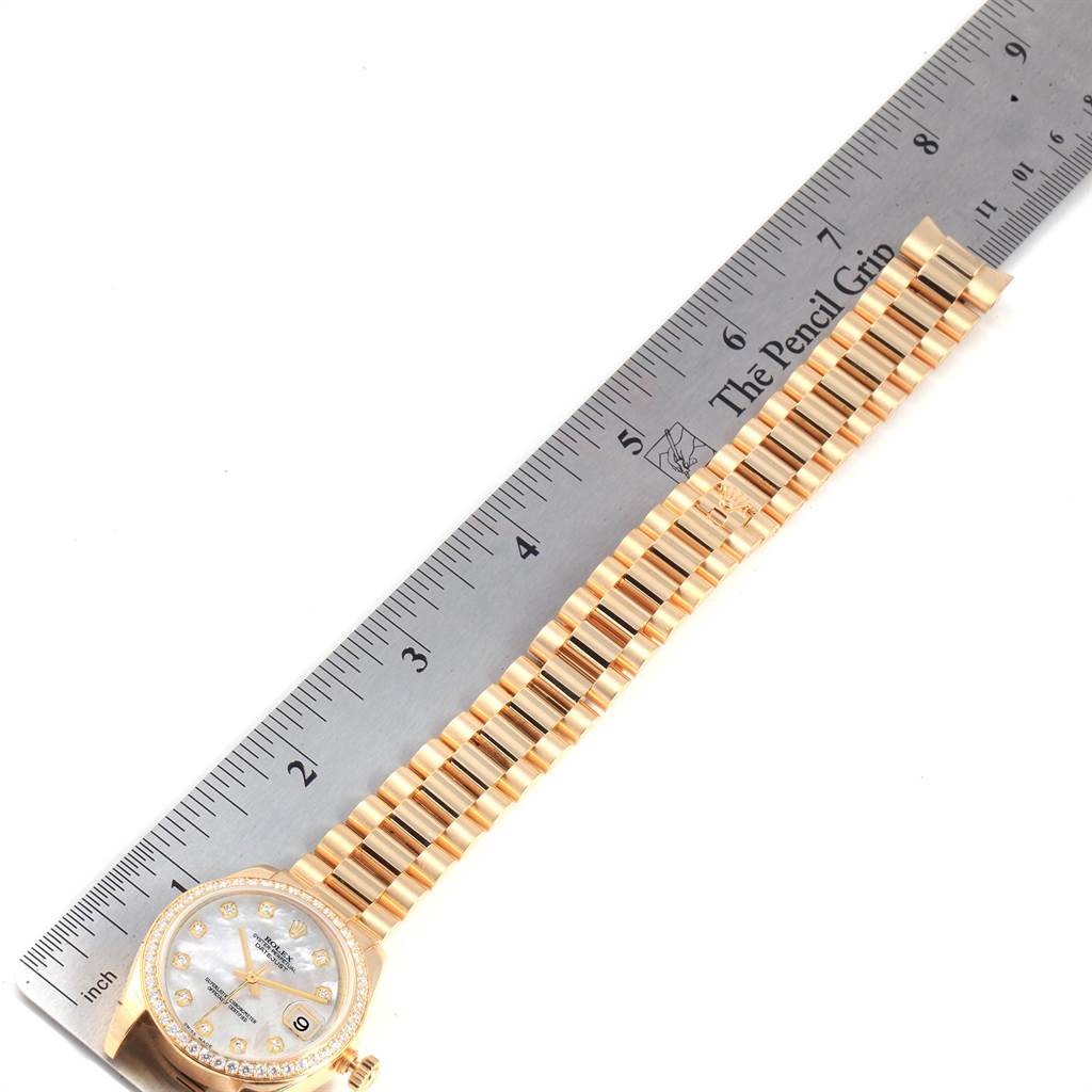 The image shows the face and bracelet of a Rolex President 178288 Women's Yellow Gold Mother of Pearl Dial 178288 Women's Yellow Gold Mother of Pearl Dial model watch laid next to a ruler.